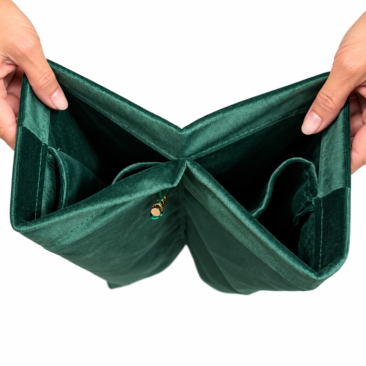 A close-up of a green velvet rack bag being held open by a hand, showing the plush texture of the exterior and lining against a white background.