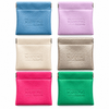 Six small textured leather card holders or wallet-style pouches arranged in a 2x3 grid on a white background. The top row includes blue and lavender, and the bottom row includes cream, metallic gold, bright pink, and green.